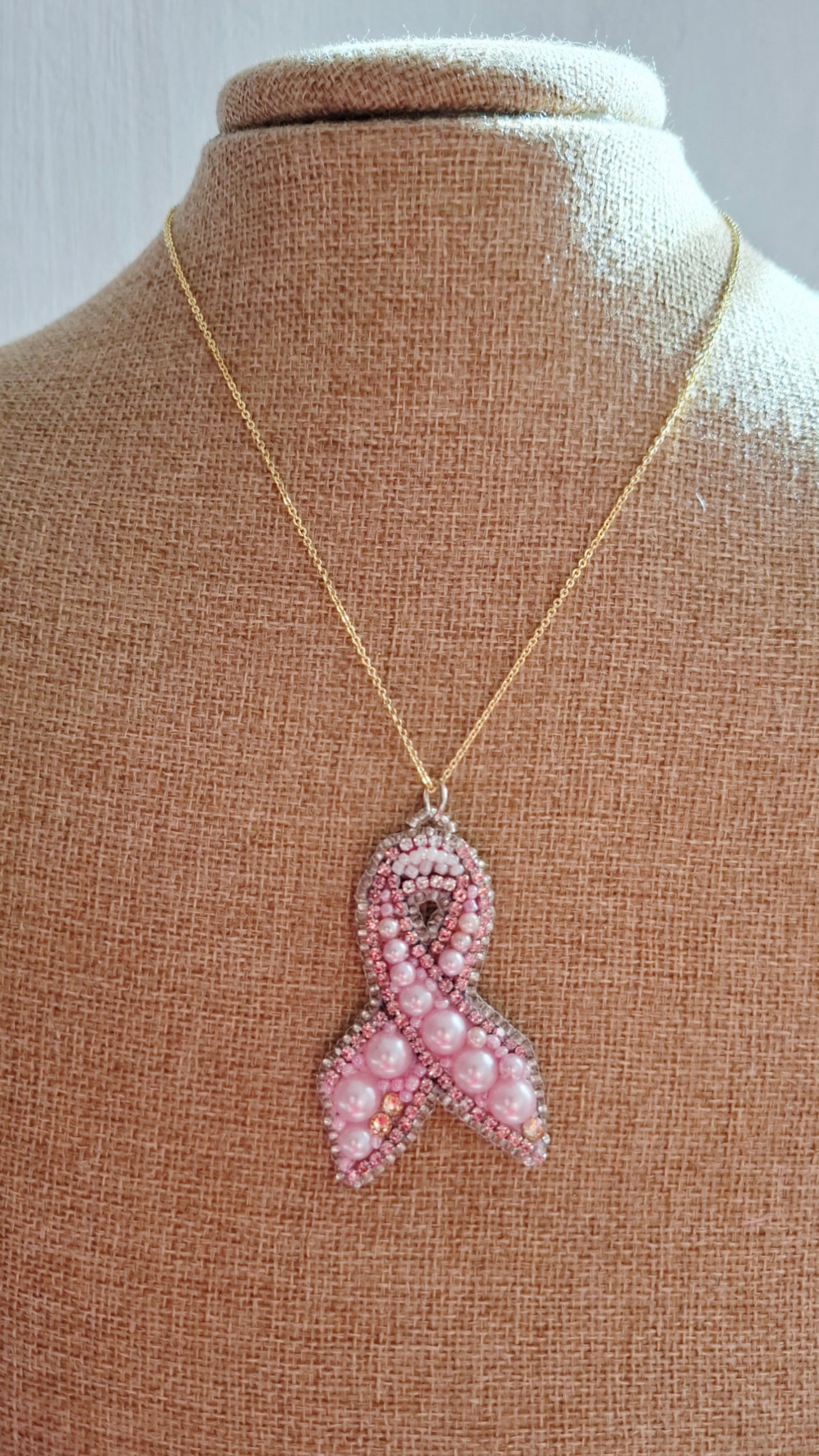 Collar con colgante de lazo rosa.